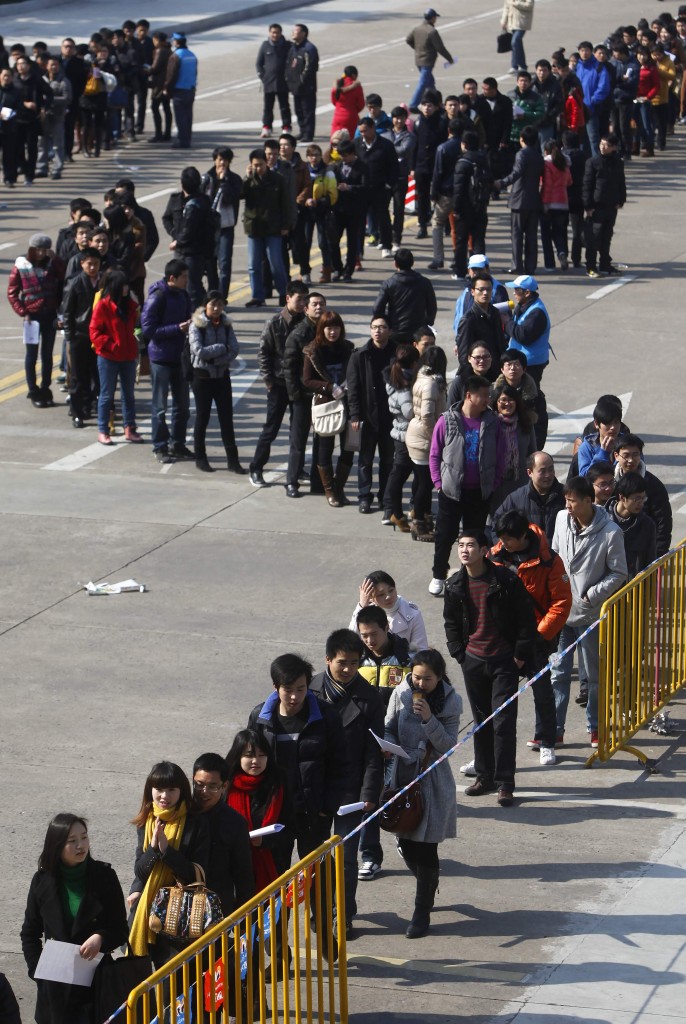 Cinesi in coda allo stadio di Shanghai per una fiera del lavoro