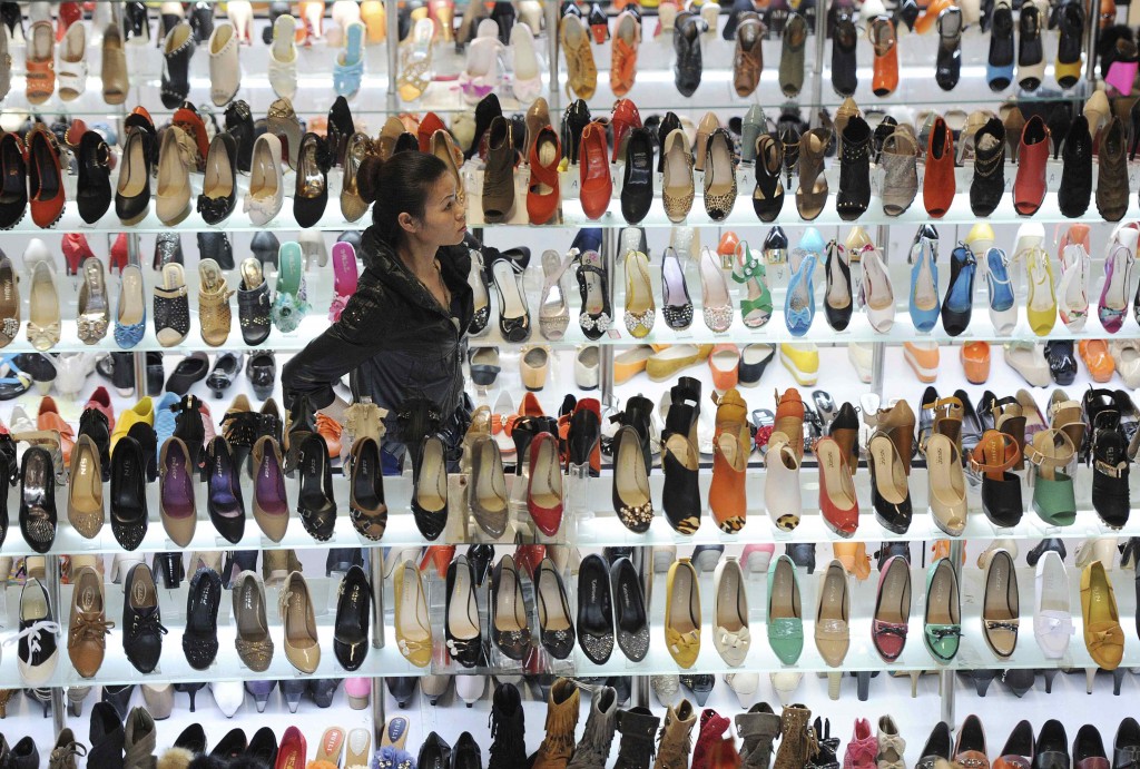 Una donna tra scaffali di scarpe in un mercato di Hefei