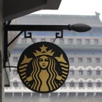 Il logo di Starbucks sullo sfondo della porta Zhengyang, a pochi passi da piazza Tiananmen a Pechino