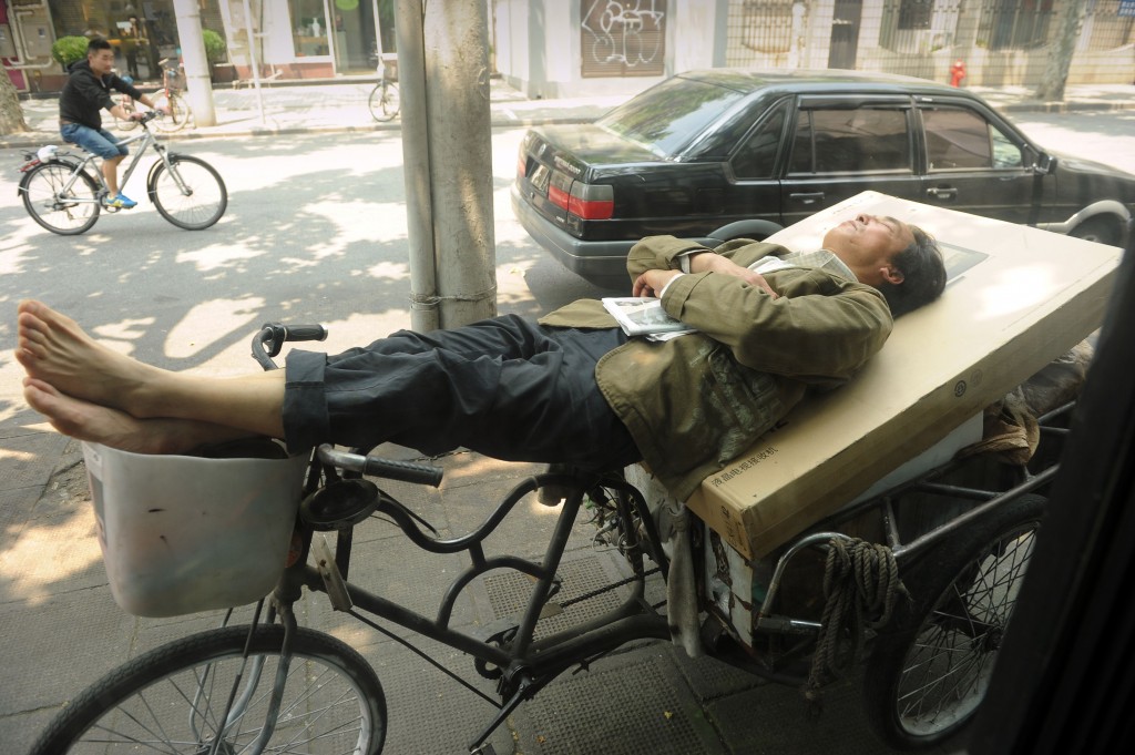 Un fattorino riposa per le strade di Shanghai