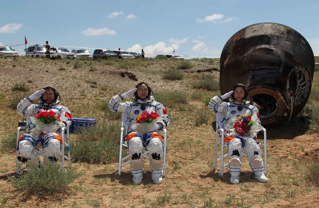 I tre “taikonauti” in posa di fronte alla loro capsula spaziale