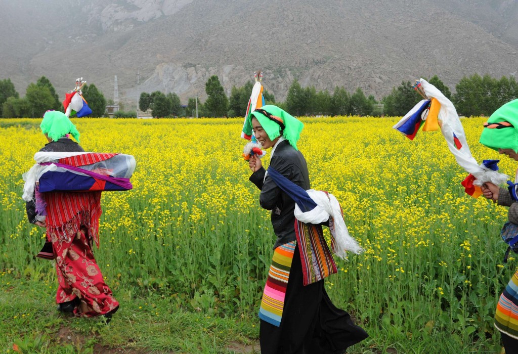Le donne del villaggio pregano intorno ai campi per la festa di Quguo
