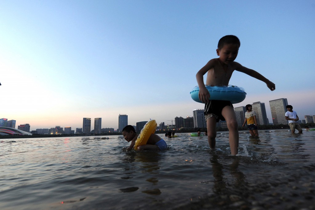 Un bimbo gioca nel fiume a Hefei