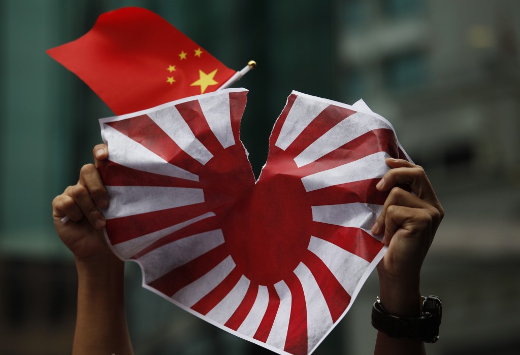Manifestanti rompono la bandiera del Giappone Imperiale protestando per gli arresti