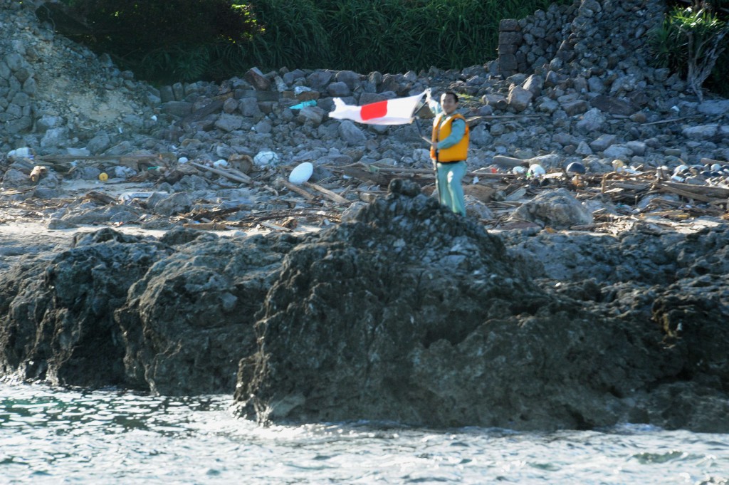 Un attivista sventola la bandiera nazionale giapponese sulle isole Senkaku