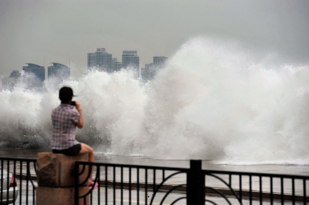 Una ragazza fotografa le onde del tifone Bolaven a Qingdao