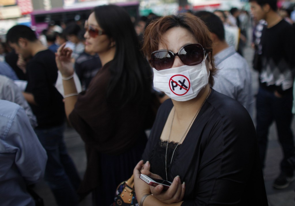 Protester wears a mask with a reference to the chemical paraxylene, during a protest against plans to expand a petrochemical plant in Ningbo